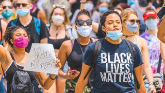 Folkemengde demonstrerer mot rasisme i USA. Kvinner og menn med "Black Lives Matter"-t-skjorter. Flere har p&aring; munnbinn for beskyttelse mot covid-19.